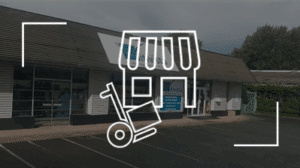 Bâtiment commercial avec devanture Vitrvista, icônes de magasin et diable de manutention superposées en blanc.